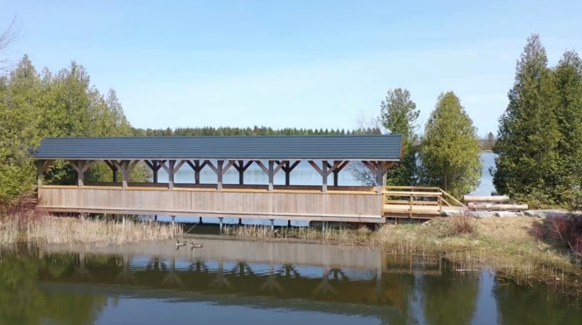 View of a wooden covered bridge running across Island Lake